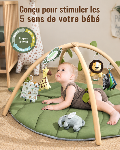 Bébé allongé sur un tapis d'éveil sensoriel sous l'arche de jeux